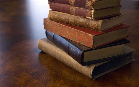 A stack of old books on a wooden surface wallpapers and ...