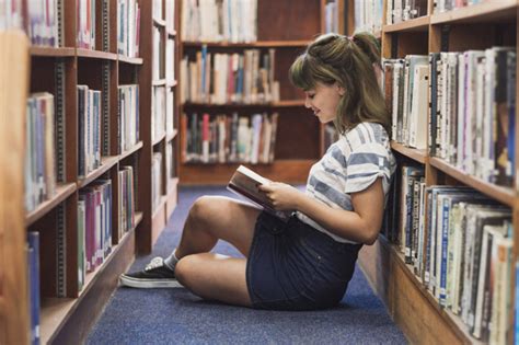 Chica leyendo en una biblioteca | Descargar Fotos gratis