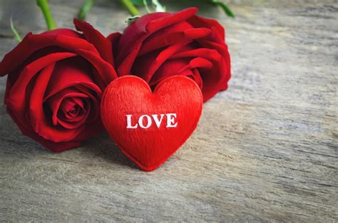 Corazón rojo con texto de amor y flores rosas rojas sobre superficie de ...