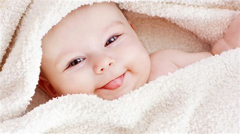 Cute Baby Covered With White Woolen Towel With Tongue Out ...
