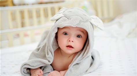 Cute Child Baby Is Lying Down On White Bed Covered With ...