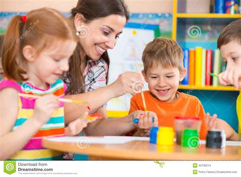 Cute Children Drawing With Teacher At Preschool Class ...