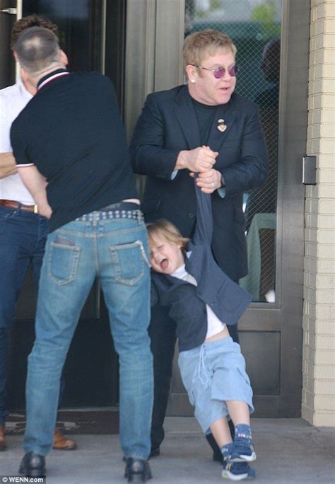 Elton John playfully swings their son Zachary after a family meal ...