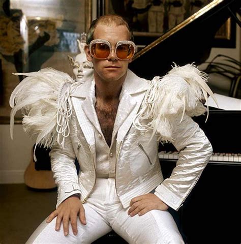 English pop singer Elton John in a flamboyant stage outfit of white ...