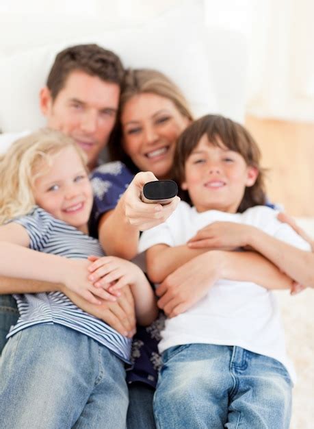 Familia unida que ve la televisión que se sienta en el sofá | Foto Premium