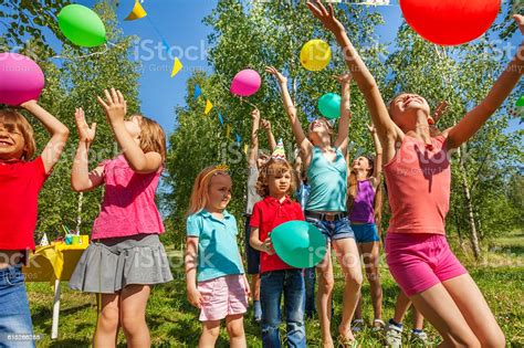Happy Kids Playing And Catching Colorful Balloons Stock ...