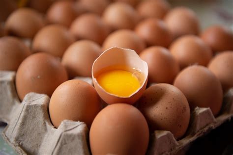 Huevos de gallina y medio huevo roto con yema, los huevos son escasos y ...