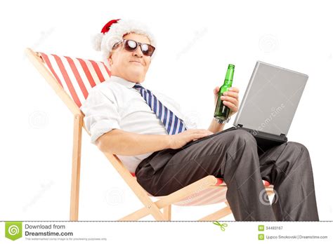 Mature Businessman With Santa Hat On A Chair, Drinking ...