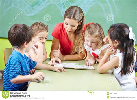 Nursery Teacher Reading Book Aloud Stock Photo   Image of ...