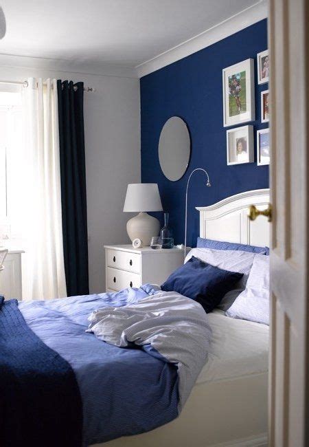 pared de cabecero en azul marino, cama en tonos de azul y ...