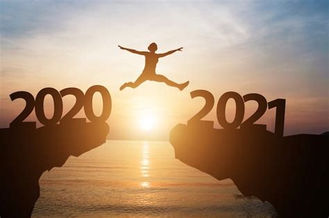Premium Photo | Man jumps from year 2020 to 2021 with sunlight and sea ...