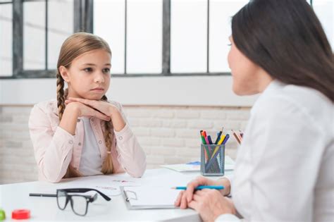 Psicólogo del niño joven que habla con la niña triste en la oficina ...