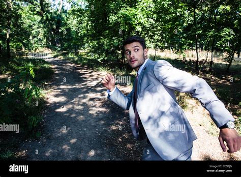 Scary businessman running away from something outdoors in ...