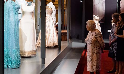 The Queen visits exhibition showcasing 150 of her outfits ...