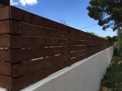 Un muro de obra con valla DIY de madera en el jardín ...
