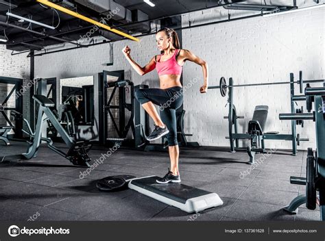 Woman exercising in gym Stock Photo by DimaGavrish 137361628