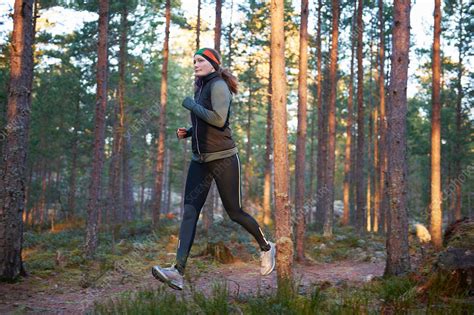 Woman running in forest   Stock Image   F005/2784   Science Photo Library